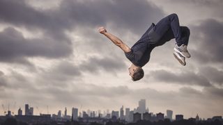 A man doing a flip in front of a stormy sky wearing the Jabra Elite 7 Active