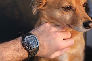 The G-Shock Move smartwatch on wrist with dog in background