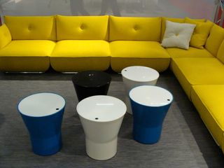 Yellow L shaped sofa with 2 cushions (yellow and white) and 5 drum-like side tables in different colours