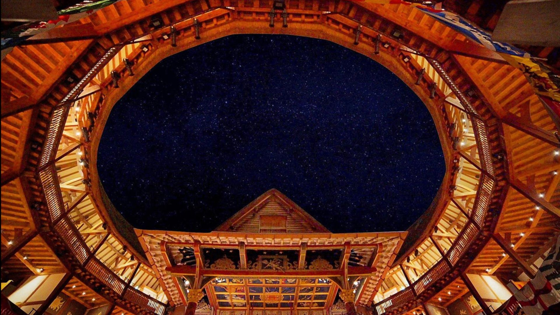 an image of the roof / ceiling at The Globe theatre showing the upper seating and top part of the stage with a summer midnight sky above