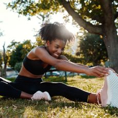 Running tips: A woman stretching her legs after a run