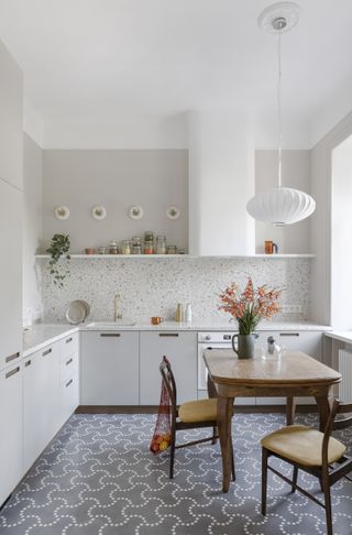 A white kitchen with patterned floor tiles