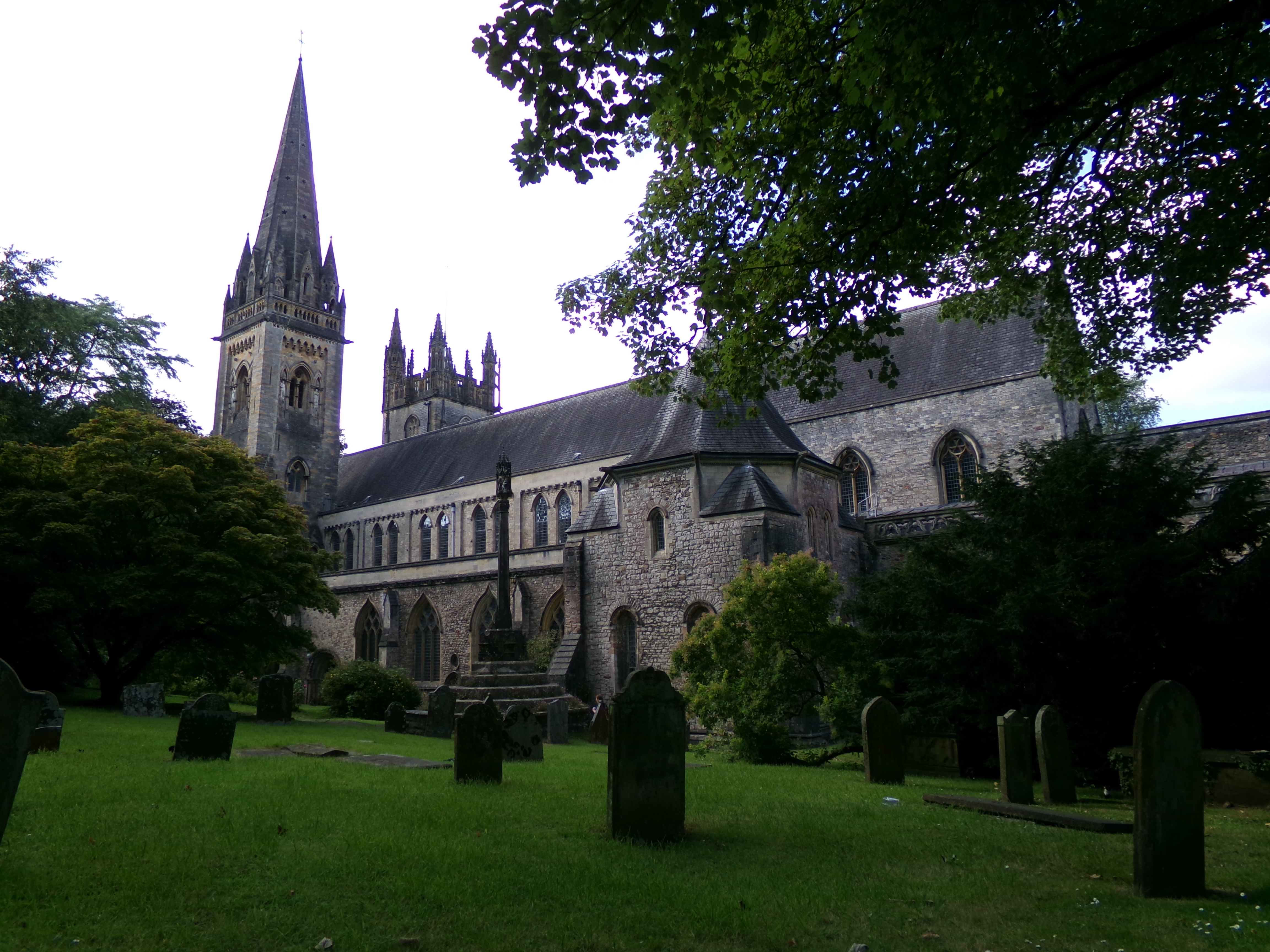 Outside of a large church surrounded by a grassy lawn and trees