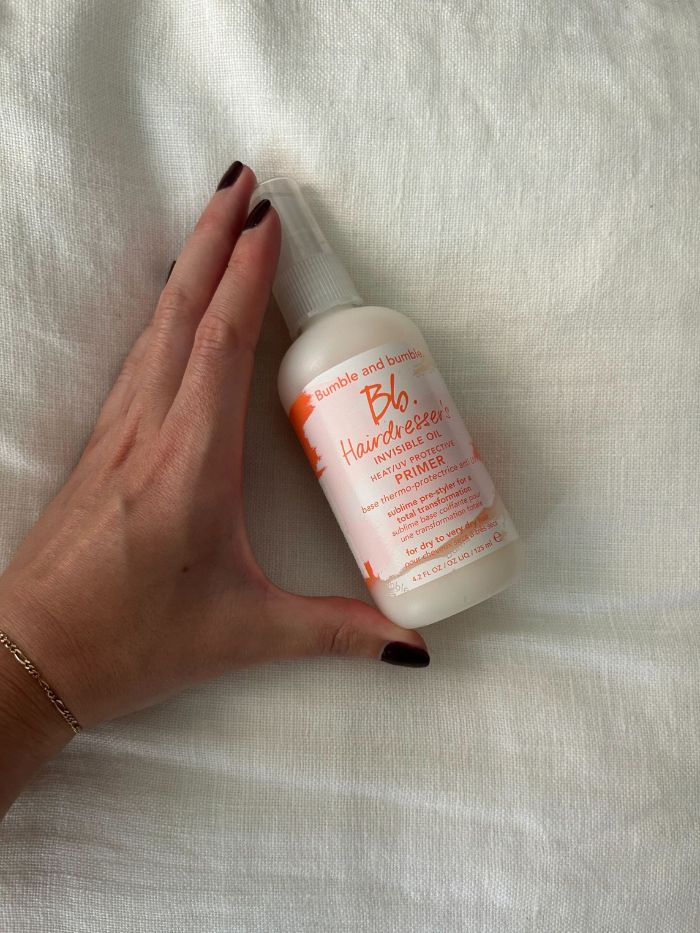 junior beauty editor grace lindsay holding a bumble and bumble hair primer