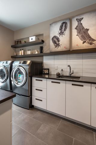 Laundry room with open shelving and prints