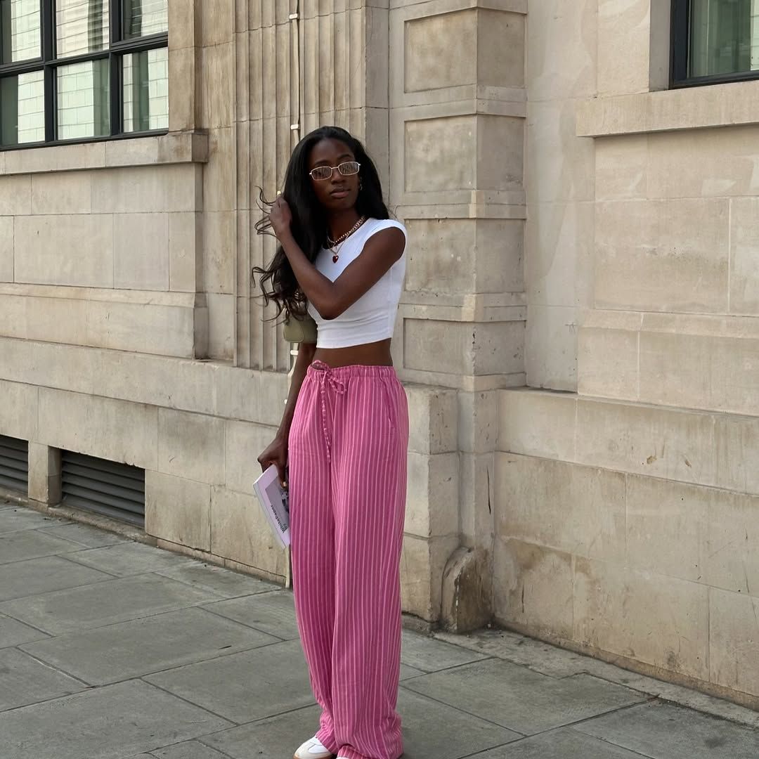 fashion influencer in pink pinstripe trousers and white crop tee