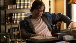 Mark Wahlberg looking defiant while sitting in an office in Father Stu.