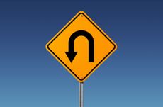 Yellow U Turn Sign Isolated On Blue Sky