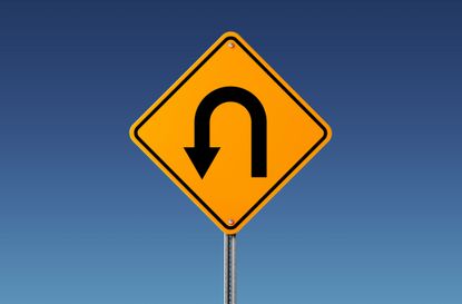 Yellow U Turn Sign Isolated On Blue Sky