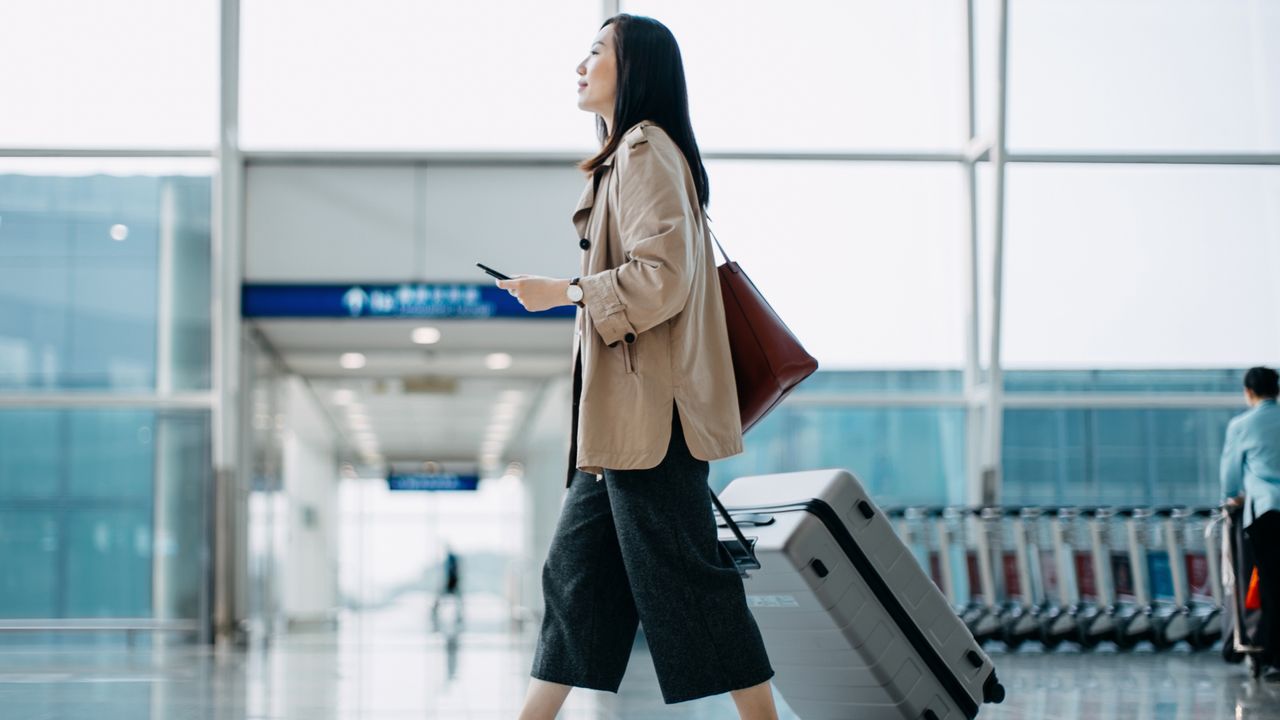 woman in airport with suitcase