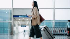 woman in airport with suitcase