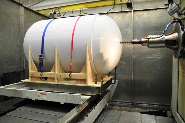 3D printer working in space, possibly printing a tiny space helmet for a hamster.