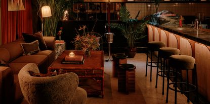 A dazzling New York bar with plush textiles, rich wood tones, and golden lighting.