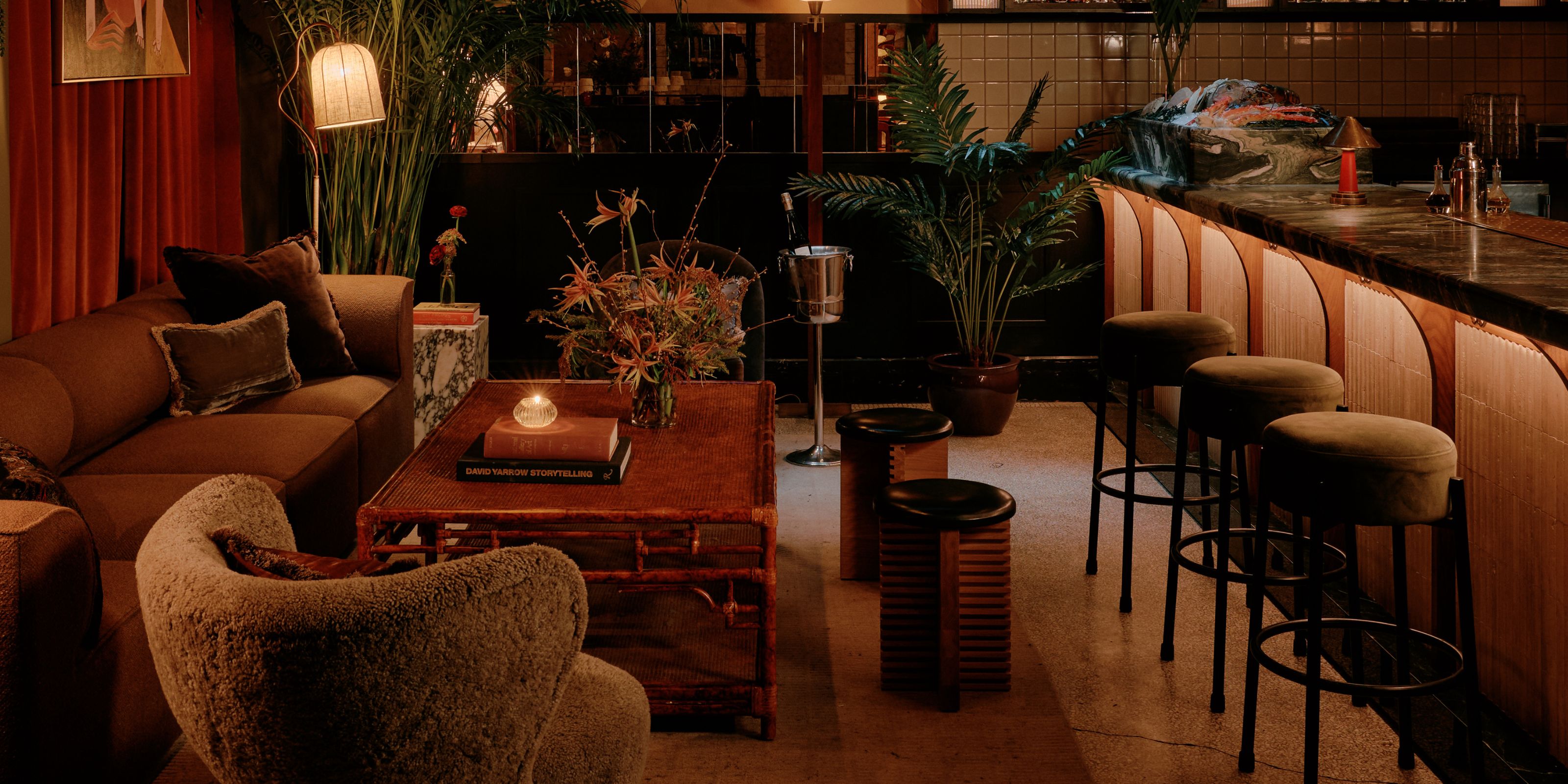 A dazzling New York bar with plush textiles, rich wood tones, and golden lighting.