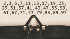 List of prime numbers below 100 on paper in vintage type writer machine from 1920s closeup with paper.