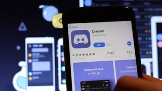 Discord icon on phone screen with logo on blurry background, Illustrative Editorial