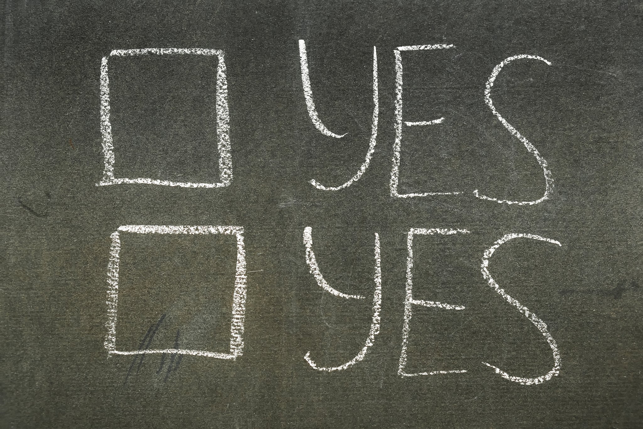Two checkboxes on a chalkboard, both say yes