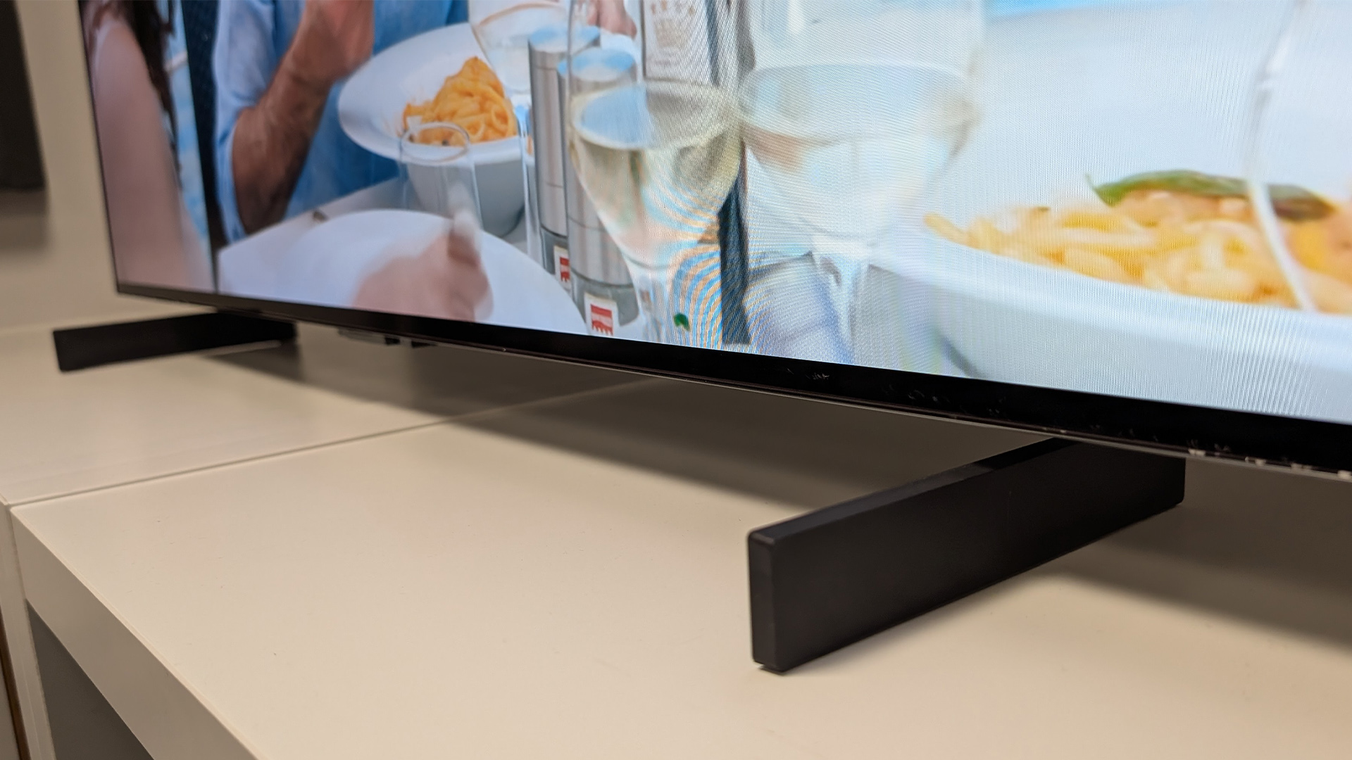 LG C5 42-inch OLED TV on white wooden surface, detail of feet