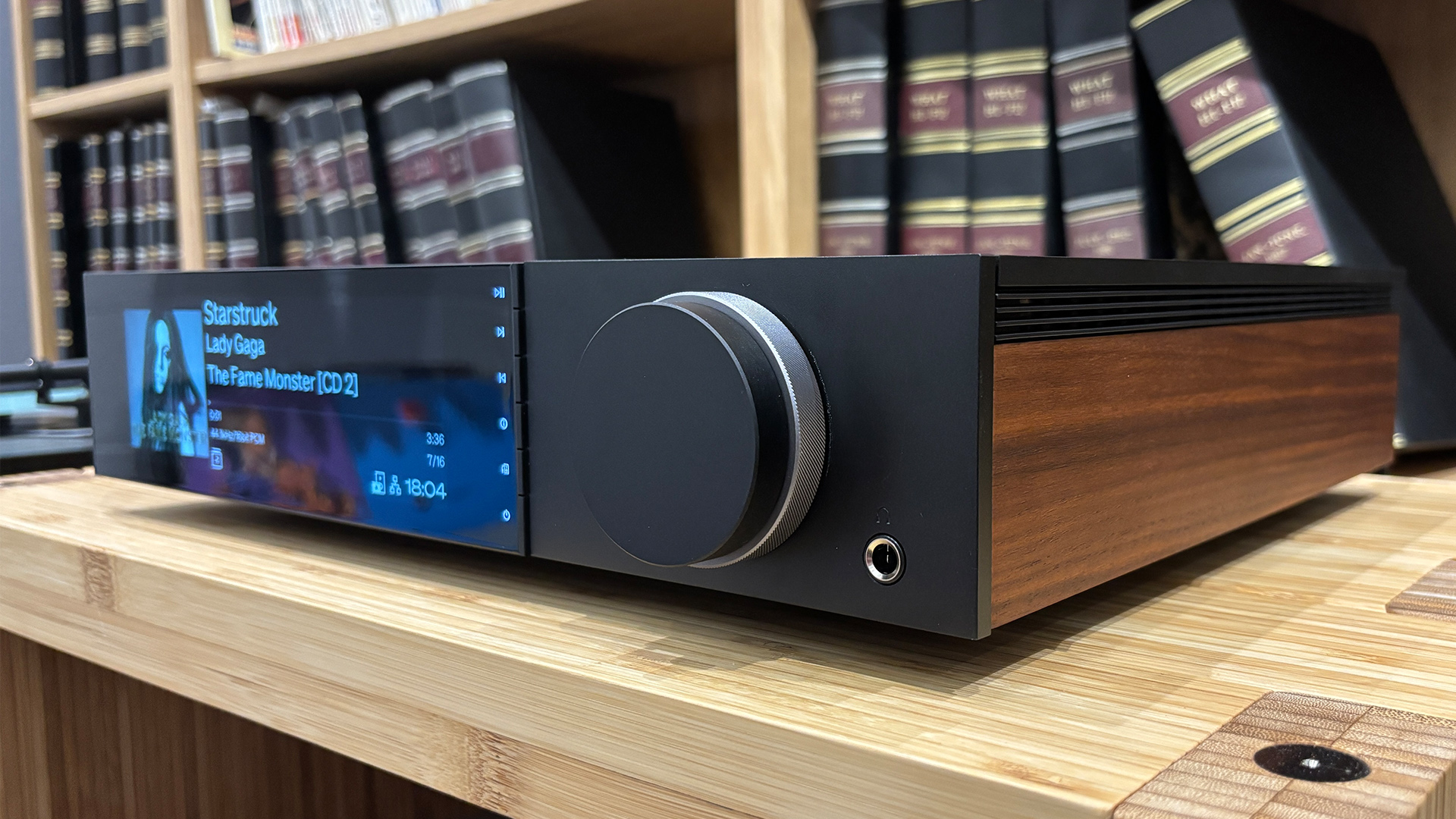 Cambridge Audio Evo 300 all-in-one system on wooden hi-fi rack in front of bookcase