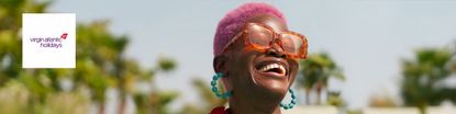 Virgin Holidays logo top left with a wide image of a woman with pink hair smiling happily in Dubai