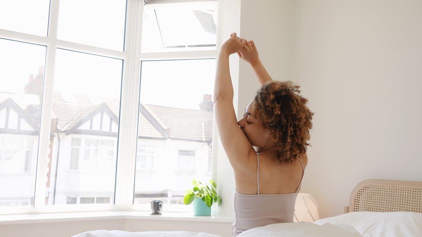 a woman stretches as she gets out of bed