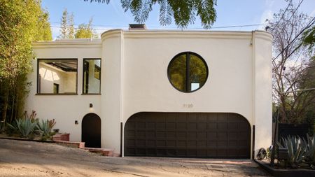 white house with large black garage door, black front door and three black windows