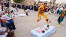 A man jumps over a mattress