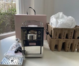Grind One Pod Machine on the countertop with packaging around it