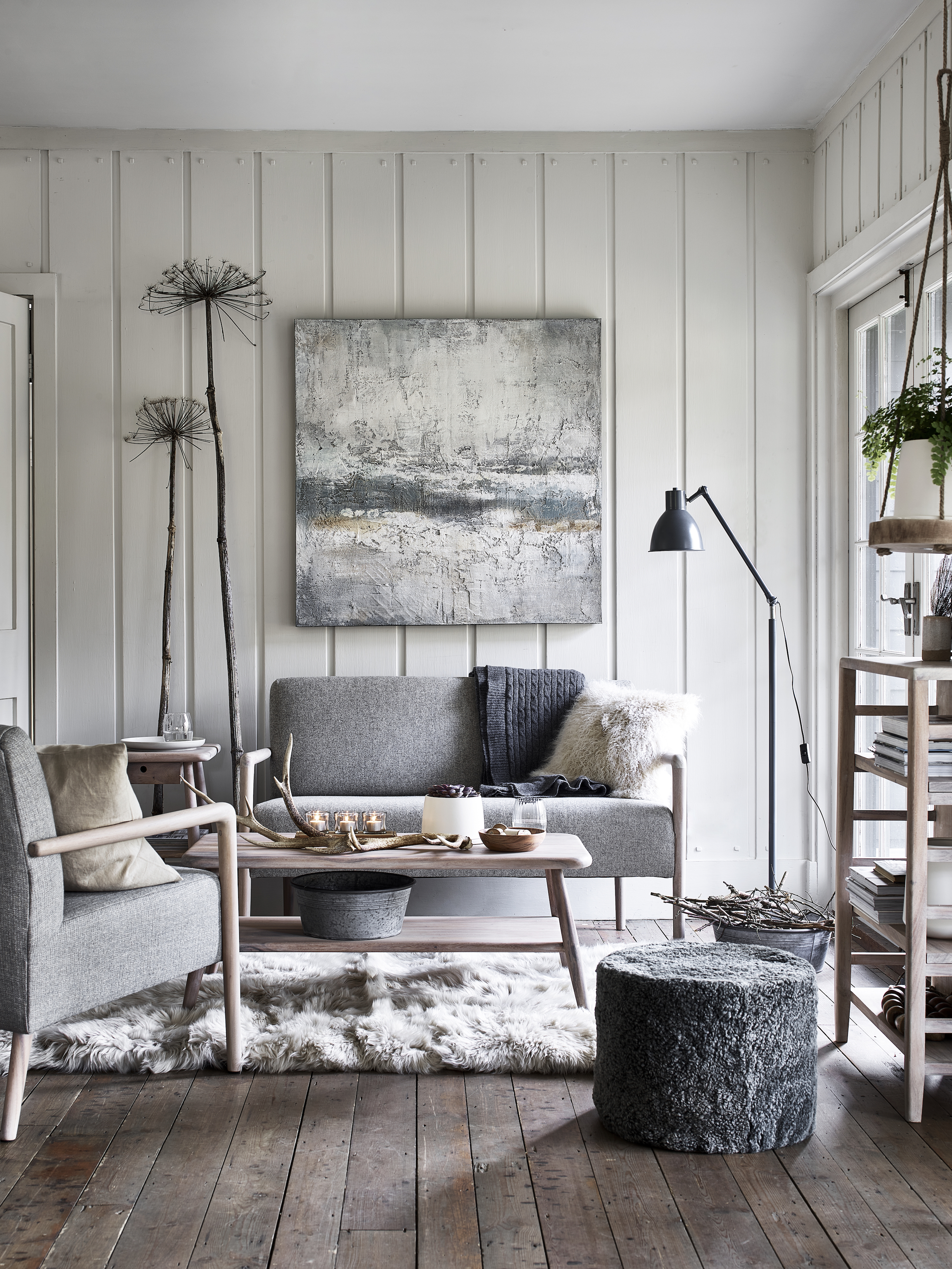 living room with floorboards, wood panelling and artwork on wall