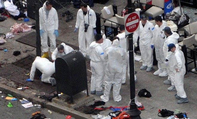 Investigators in white jumpsuits work the crime scene on Boylston Street on April 16.