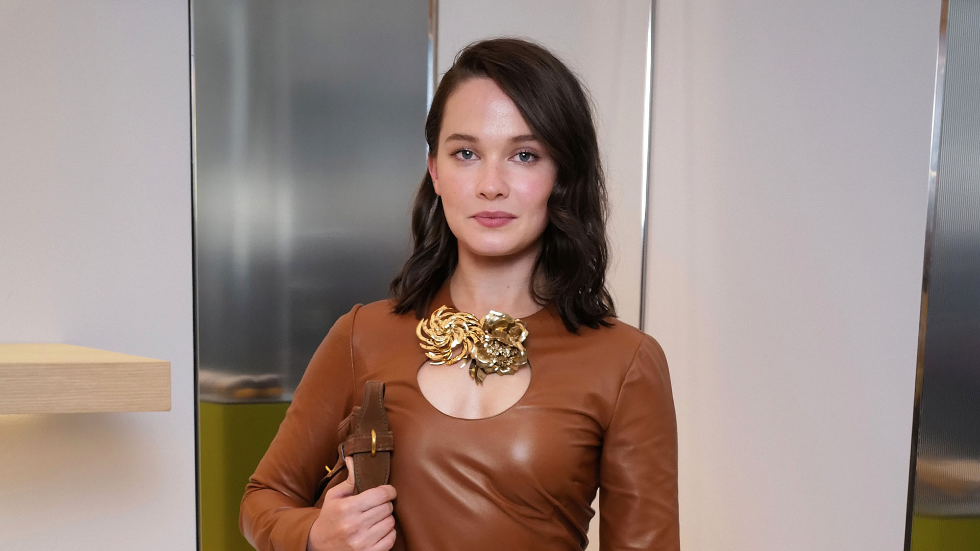 Cailee Spaeny weaing a miu miu brown long sleeve and yellow skirt