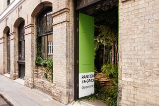 Brick building with big doors painted in Pantone Greenery