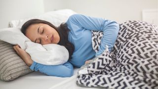 Woman asleep covered in a weighted blanket and a low tog duvet