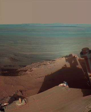 NASA's Mars Rover Opportunity catches its own late-afternoon shadow in this dramatically lit view eastward across Endeavour Crater on Mars. Most of the component images were recorded during the 2,888th Martian day, or sol, of Opportunity's work on Mars (March 9, 2012).