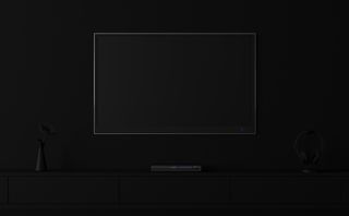 Minimal style image showing a TV and entertainment centre on a wall in a dark room