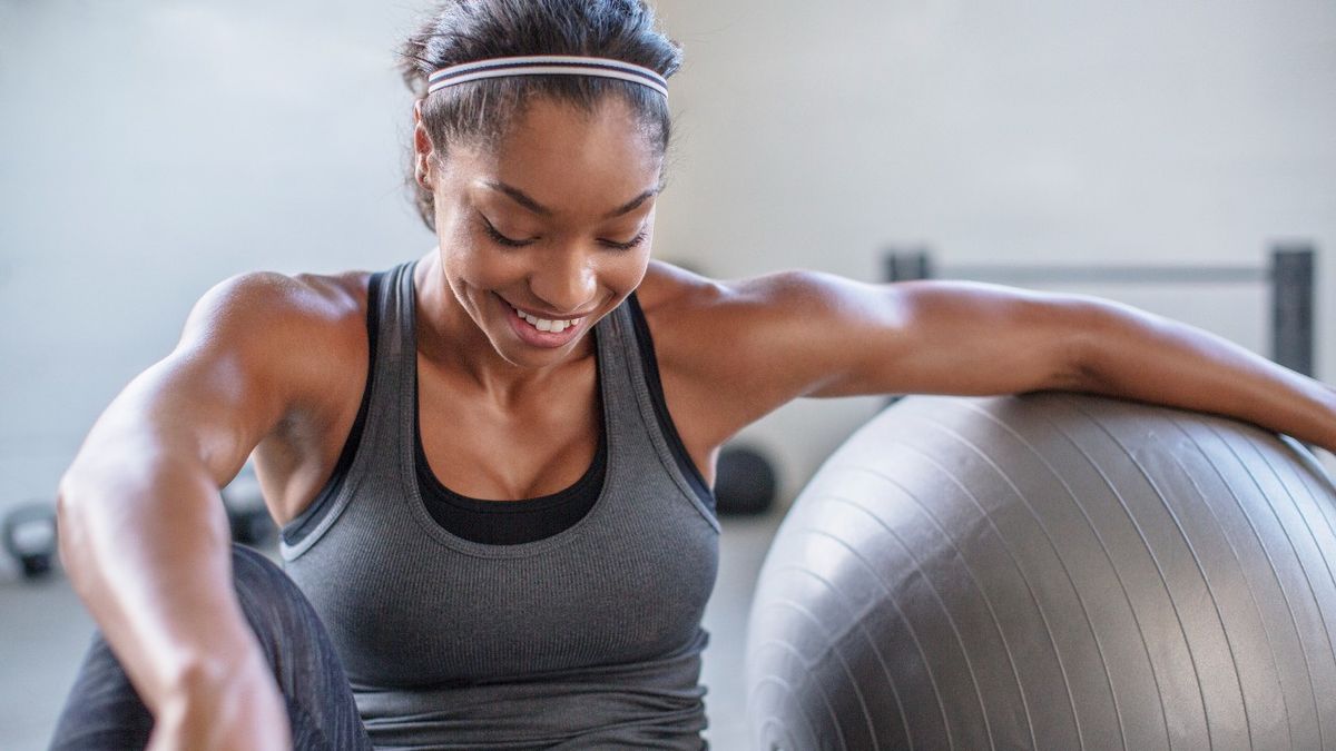 Woman rests her arm on a gym ball