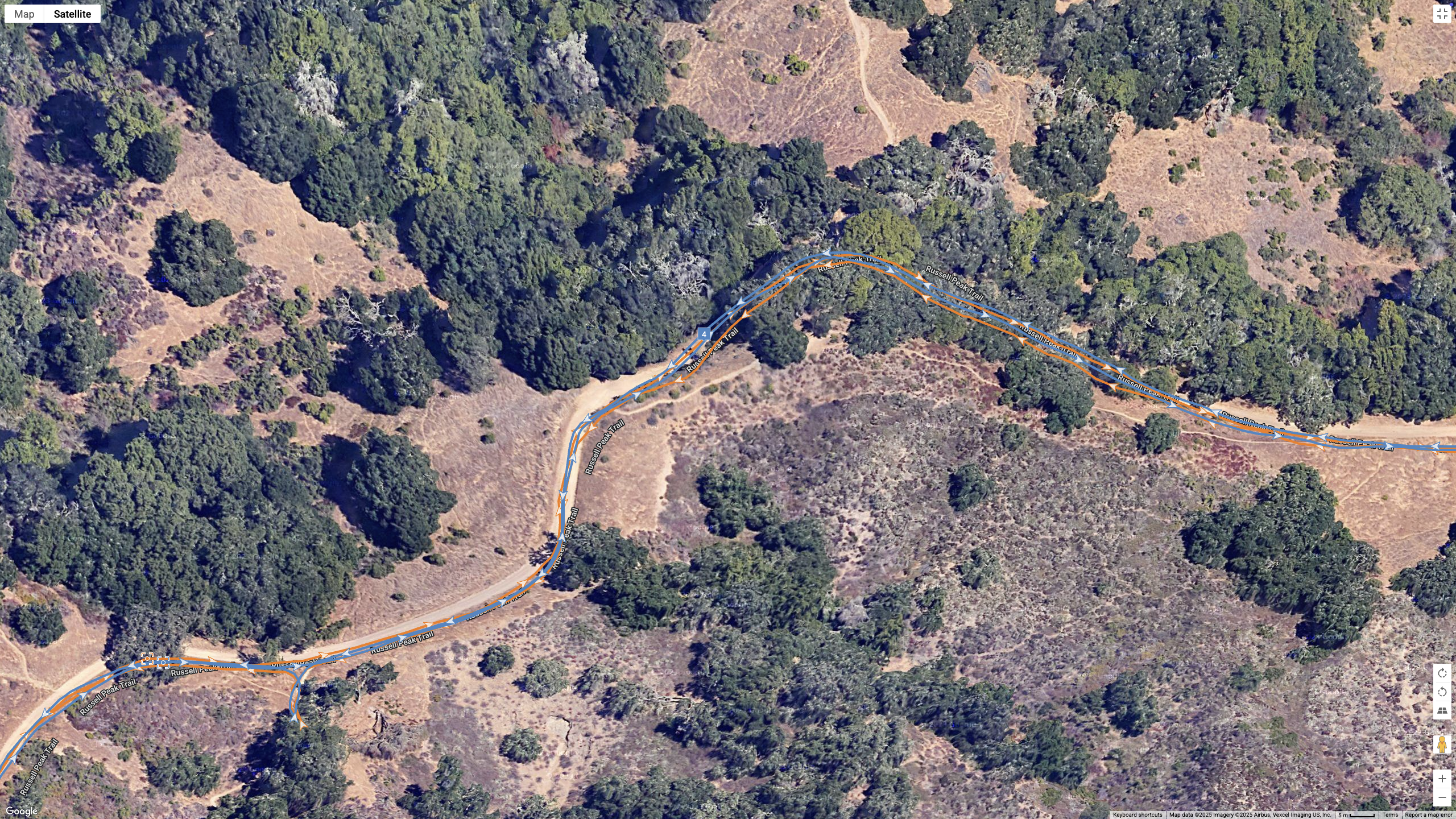 A Google Maps satellite view showing how the COROS APEX 4 (blue) and Garmin Forerunner 970 (orange) compare for GPS-tracked accuracy on a hilly, windy hike.