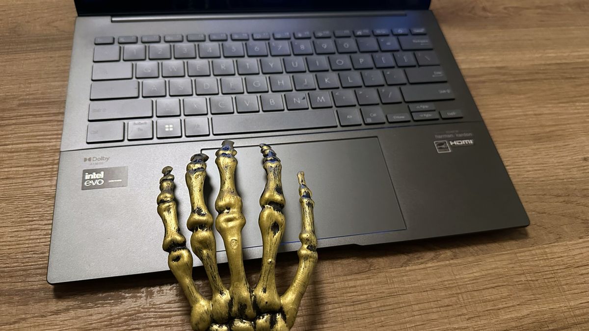 Topdown photo of Asus Zenbook 14 OLED (Q425M) open on a desk to show keyboard and touchpad