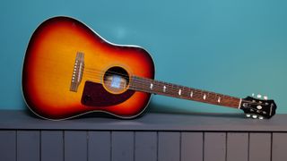 Epiphone Masterbilt Texan against a blue wall in our photo studio