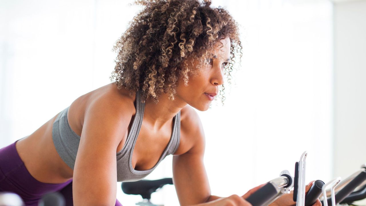 A woman on an exercise bike at the gym