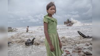 Girl standing in the ruins of her tea shop in the Sundarbans 