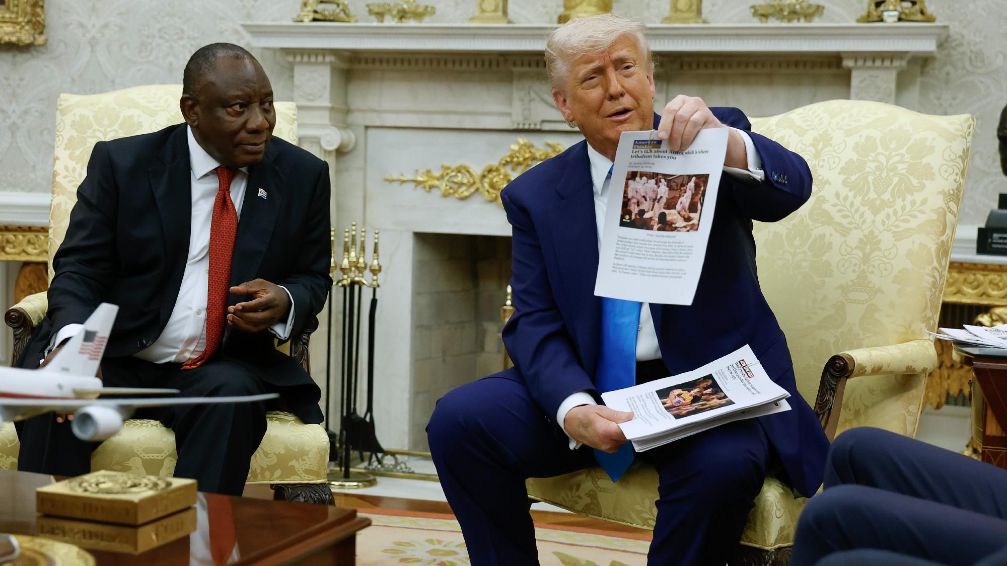 Donald Trump holds up a printed article claiming state-sanctioned violence against white farmers in South Africa during a press conference with South African President Cyril Ramaphosa in the Oval Office at the White House