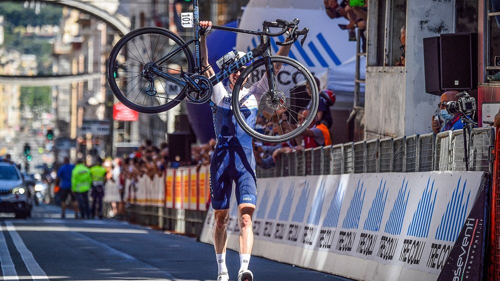 Israel Startup Nation rider holding his Factor bike in the air across the finish line