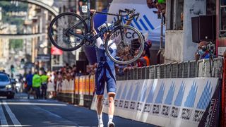 Israel Startup Nation rider holding his Factor bike in the air across the finish line