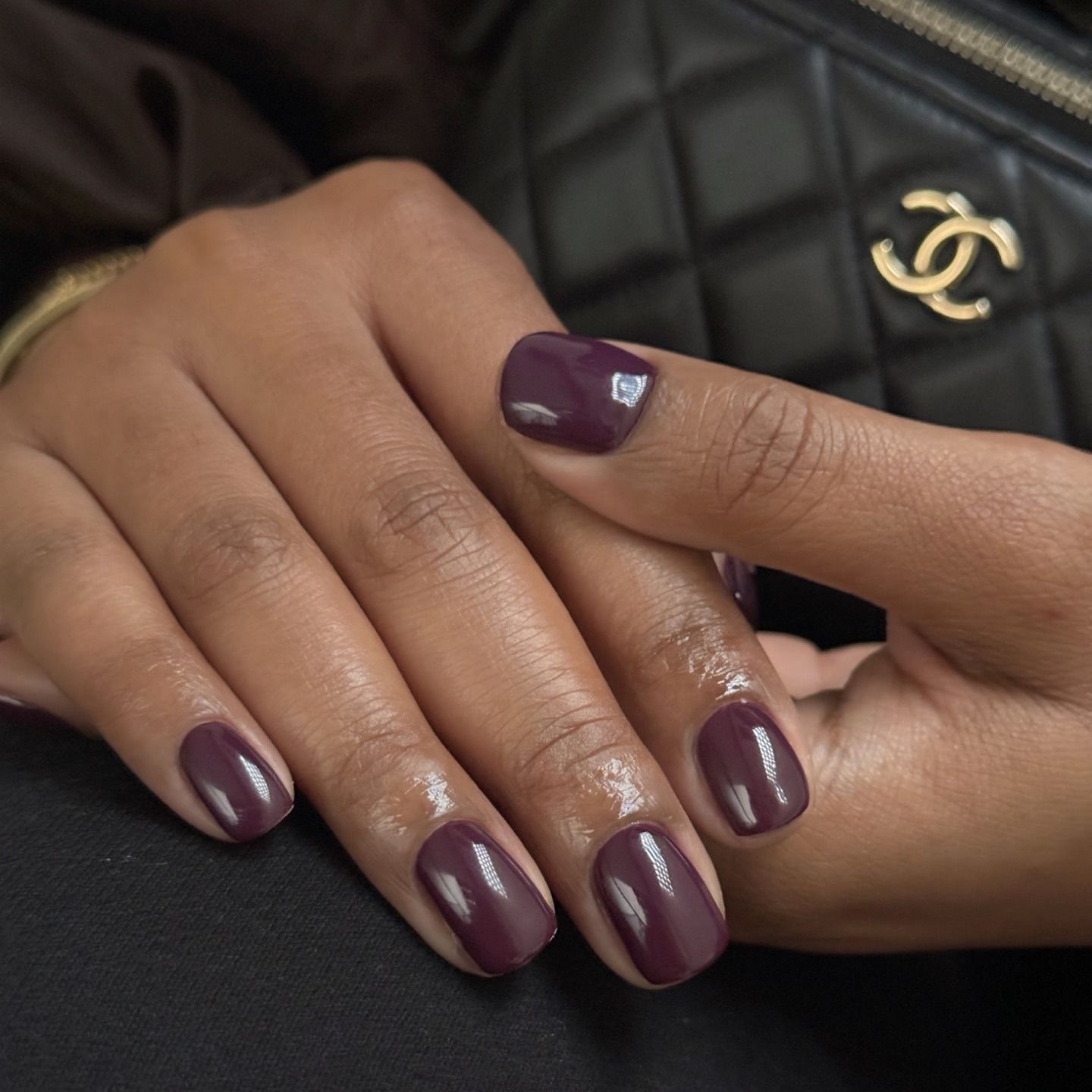 A glossy, dark purple manicure