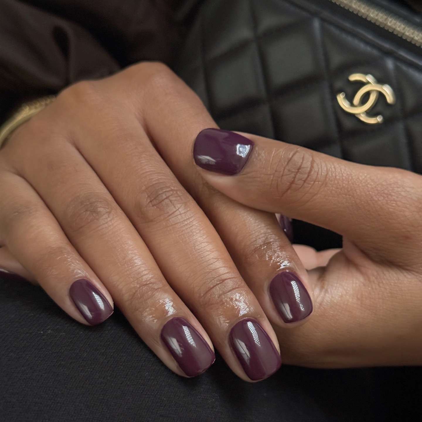 A glossy, dark purple manicure