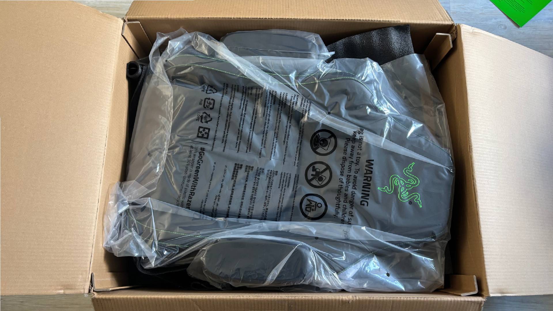 Razer Iskur V2 NewGen parts in a brown cardboard box and plastic packaging