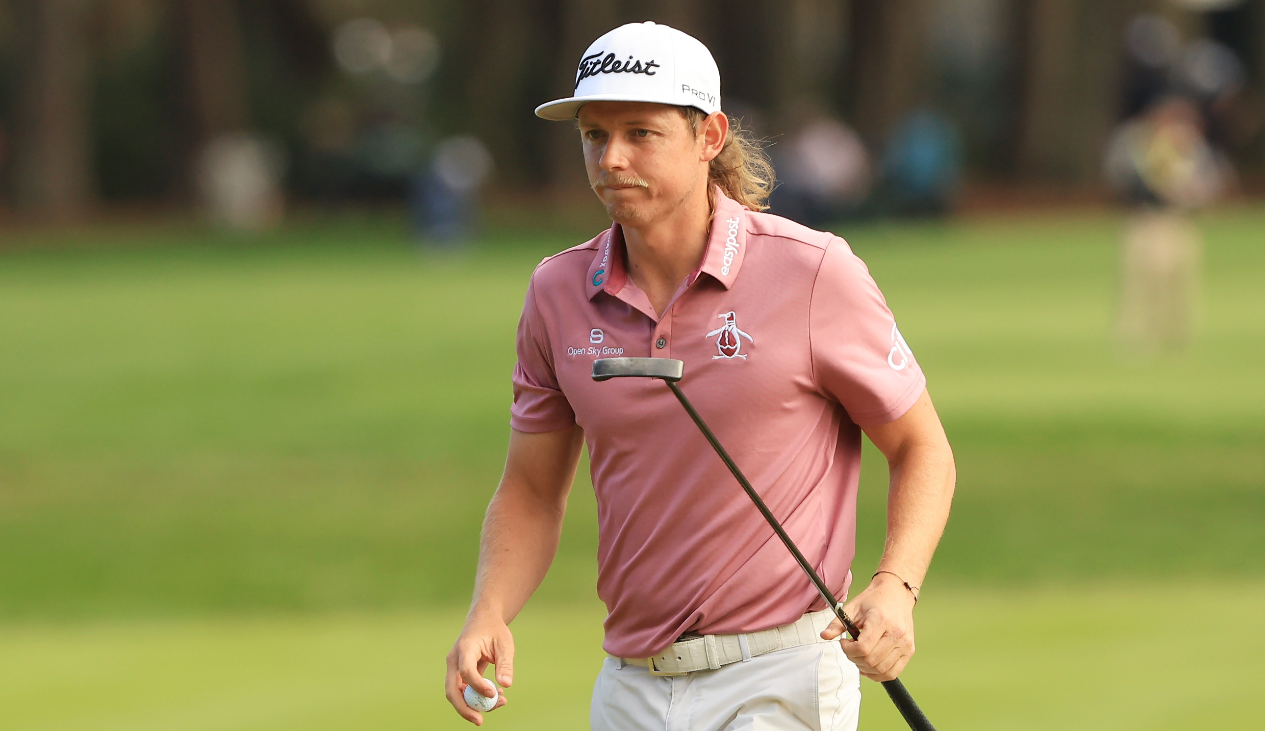 Cameron Smith walks off the green holding a putter