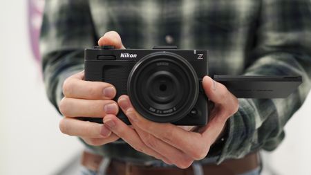 Mike Harris holding a Nikon ZR with 40mm lens in an office building