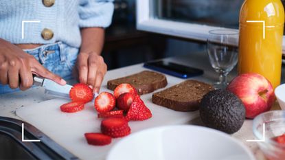 Woman chopping up berries and strawberries, the best fruit for weight loss